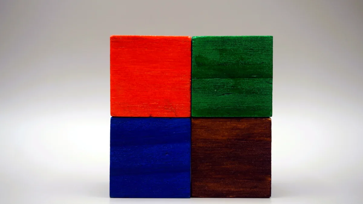 Colored wooden blocks arranged in a neat row on a white surface, a tidy grid.