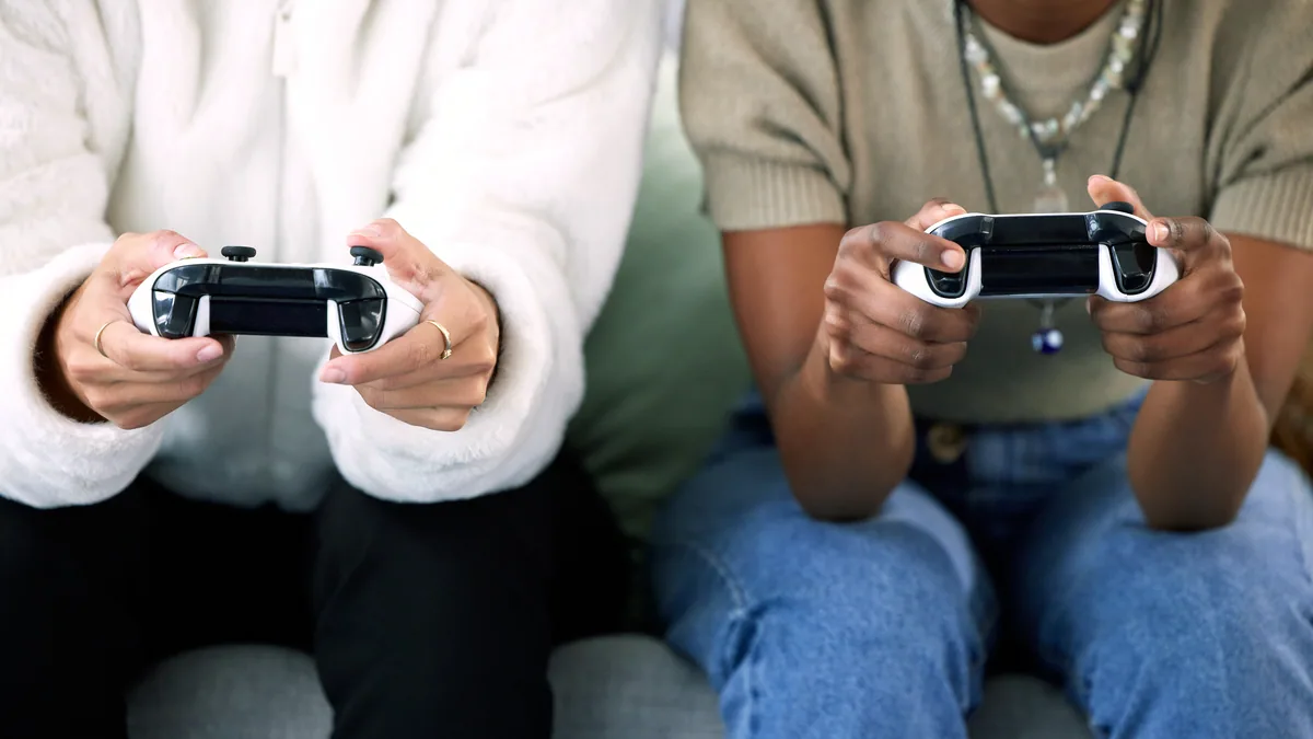 A row of game controllers lined up on a couch, each one claimed by a player.
